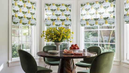 Custom - made window shades with a bright yellow lemon pattern bring a fresh punch of color to this breakfast nook designed by Emily Spanos.