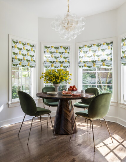 Lemony window shades bring a fresh punch of color to this breakfast nook designed by Emily Spanos. 