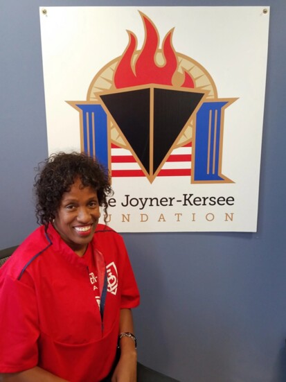 Jackie Joyner-Kersee posed in front of her foundation's logo