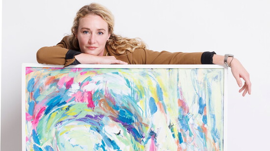 Artist Anna Sokol with one of her colorful paintings