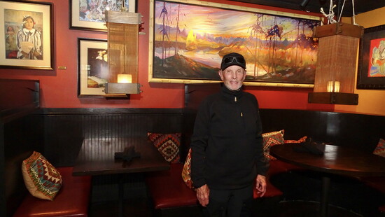 Owner Doug Lanham in front of several Gene Hackman paintings