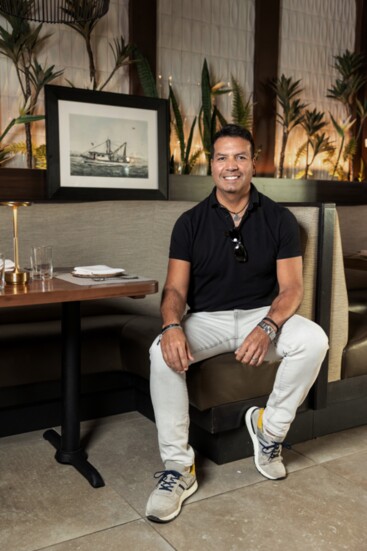 Francisco Andrés Carrión with a painting of a Galveston shrimp boat