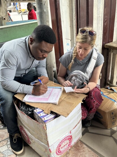 Vincent and Sheree making a list of medications on the street in front of the pharmacy.