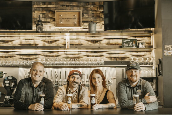 Dad “Guy” Jukes, Stacy, Kyle and Brad Jukes stand behind the bar at Jukes Ale Works, an Elkhorn staple known for its craft beer and family roots