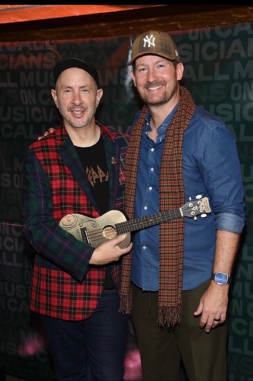 Musicians On Call president and CEO Pete Griffin (right) presents the Leadership in Music Golden Ukulele to Sam Hollander on December 11, 2023 in New York City.