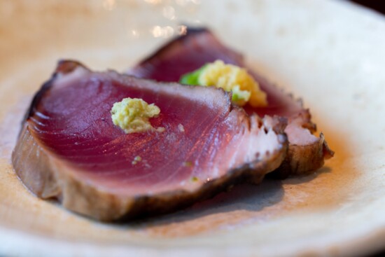 katsuo (bonito). prepared tataki style, seared and smoked in straw (hay) w/ginger on top