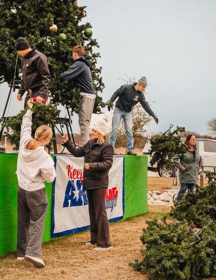 Volunteers work together to break down Christmas tree.  