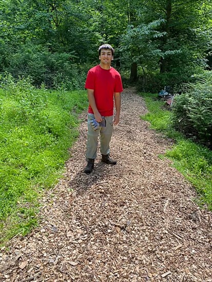 Alex stands on a trail he built near the vernal pond