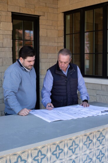 Nick and one of his team members review plans of a home being built.