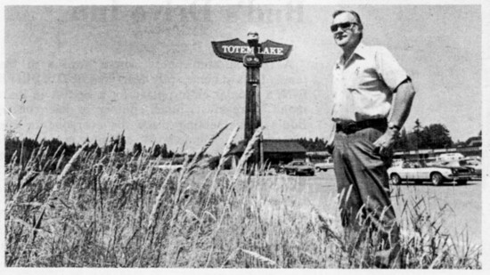 1977 Newspaper photo of Kenton in front of his Totem Lake sign.