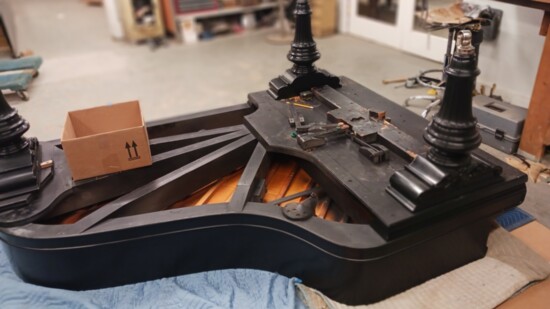 A piano at Schaeffer's Piano Company is prepped to have a player piano device installed. 