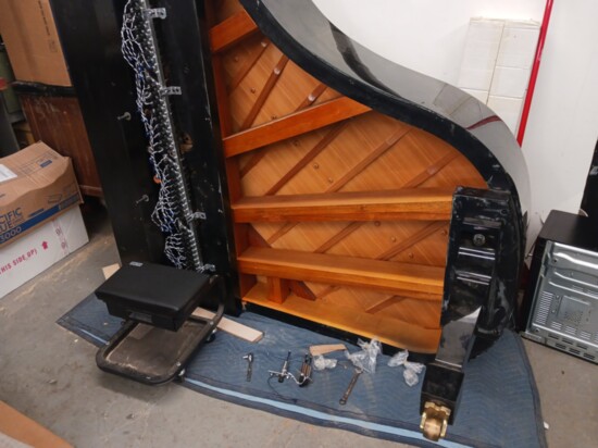 Schaeffer's Piano Company readies a grand piano for the installation of a player piano device. 