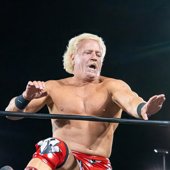 Jeff Jarrett prepares to climb up on the wrestling ring ropes.