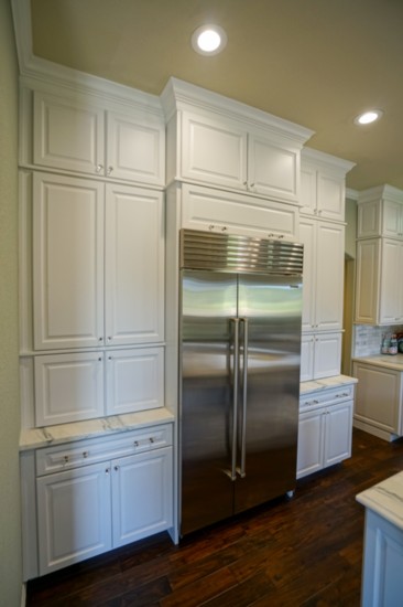 Cabinets flanking the refrigerator serve as a large pantry area. 