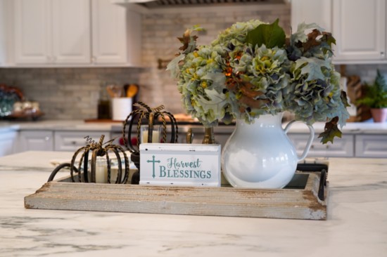 An all-white kitchen serves as a blank canvas for festive seasonal decorations. 