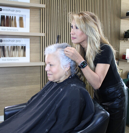 Salon owner Sandy Cieluch trims a clients hair. 