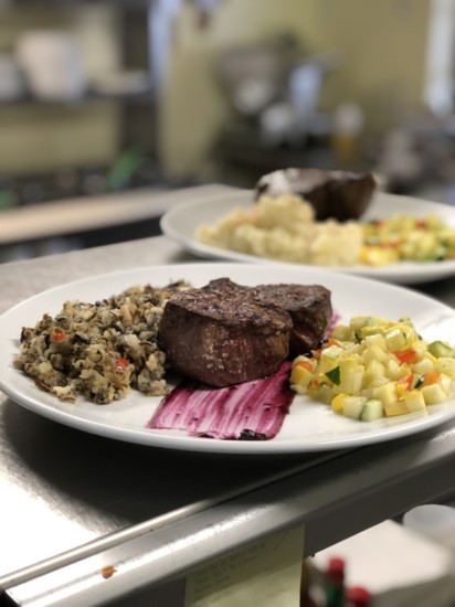Climb's chef-prepared Bison Tenderloin served over blueberry sauce with a side of summer veggies and Minnesota wild rice