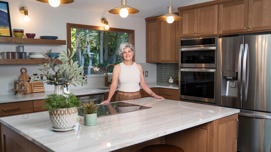 Lori Matlack beaming in her beautifully designed kitchen