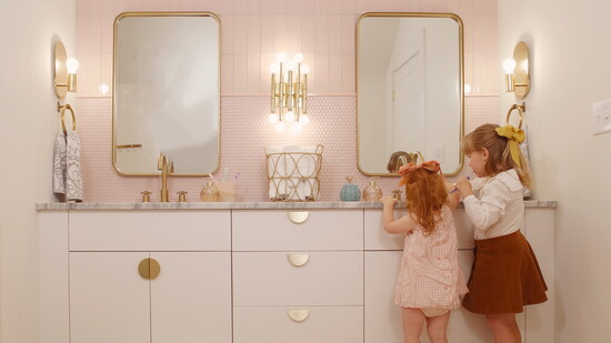 Even brushing teeth feels enchanted when the bathroom is this charming—brass fixtures and blush details for the win!