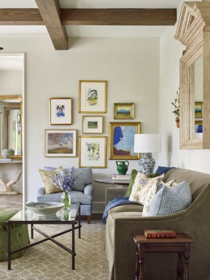 A gallery wall of art decorates this space in a family room designed by Cathy Chapman of Chapman Design. Photo by Tria Giovan