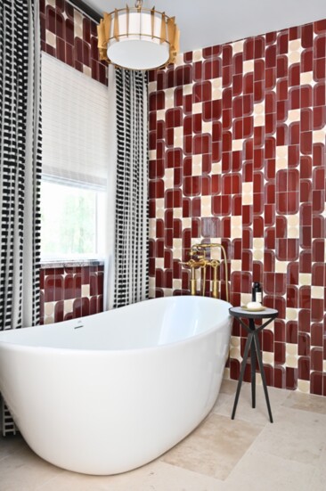 Red and white tile adds a big pop of color and style to this primary bathroo m designed by Rainey Richardson of Houston - based Rainey Richardson Interiors.