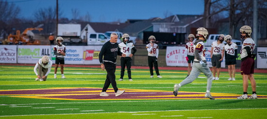 Windsor High School Head Football Coach Chris Jones leads his team through practice under the evening lights.