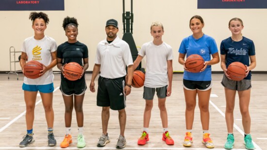 Coach Holder stands proudly with some of his students at the Basketball Laboratory.