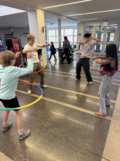 Mentors hula hoop in competition, building culture by having fun. 