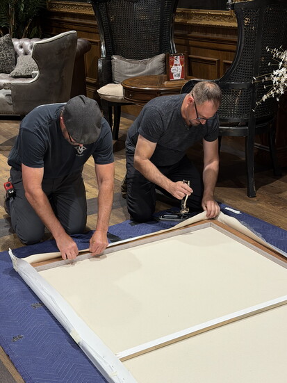 Casbeer and his brother Lee stretch a canvas for a mural painting. - Photo by Amy Tucker