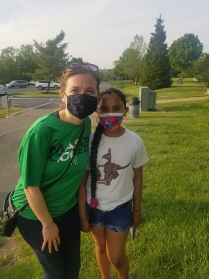 Staff facilitator from the Student Focus committee, Missy Mecum, standing with one of the BRAVE student ambassadors at their park celebration.