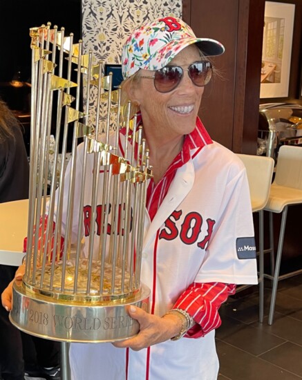 Carole Orland holding the 2018 Boston Red Sox World Series trophy.