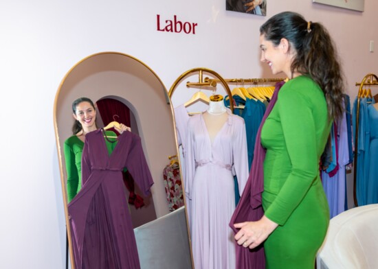 Lila Maternity owner Caitlyn Schollmeier displays one of her signature labor and delivery gowns.