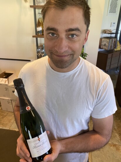 Nate Walsh holding a bottle from his first shipment of Regnier-Raffin Champagne