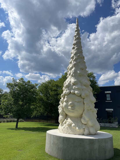 Miss Forest by Japanese artist Yoshitomo Nara greets visitors outside Center Point Art, signaling the scale and ambition of the project. 