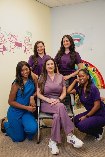 Staff members of Little Warriors Therapy Center pose with founder Colleen Tierney, center.