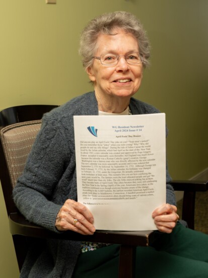 A Wesley Glen resident showcases the facility's newsletter.