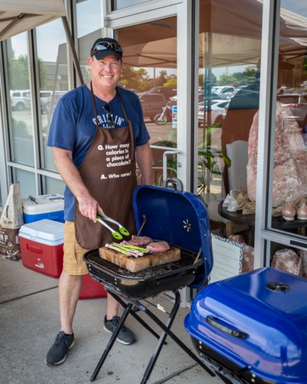 Salt MedSpa co-owner Glen Mitchell grills up some tasty treats on a Himalayan salt block sitting atop a charcoal grill.