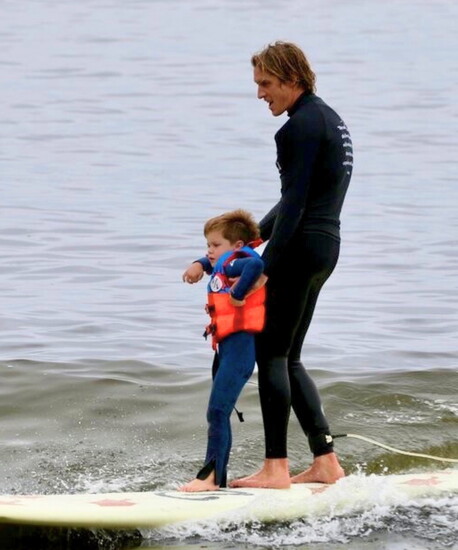 Hendrix rides the waves with his surfing instructor, finding joy and comfort in the ocean.