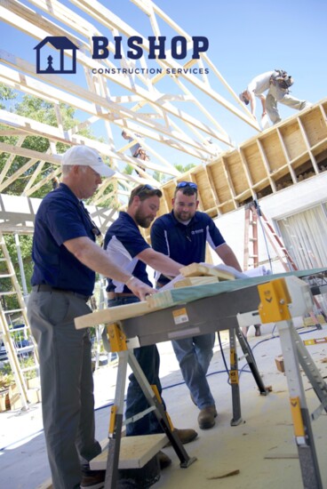 Bishop Construction Services' Project Manager Mark Mercer, Supervisor Jonathan Swartz, and Owner Michael Bishop checking plans at a worksite.