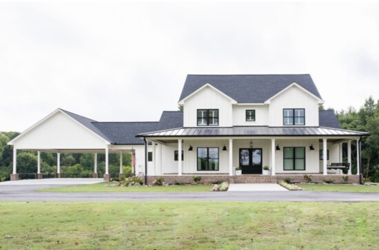 The Wood home, a modern farmhouse built in 2018 in a picturesque setting with graceful trees, has a sizable yard.