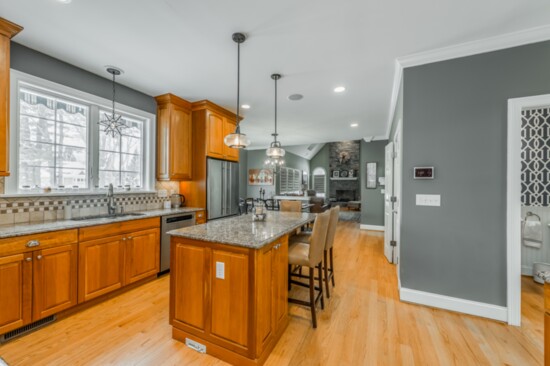 The kitchen in the home at 29 Hampton Court features granite counters, wood floors and custom light fixtures. 