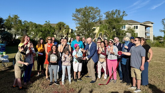 Members of Leadership Venice and Loveland Village residents gather to debut the campus’s new inclusive disc golf course.