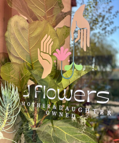 The "Mother & Daughter Owned" decal prominently displayed on J Flowers' front window.