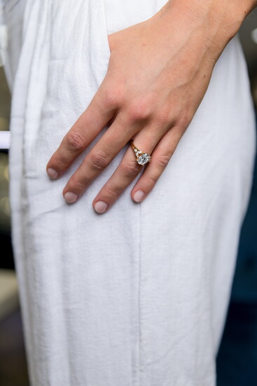 Carved Art Deco-inspired details highlight this oval-cut diamond ring with vintage appeal. Modeled by Delaney Spencer.