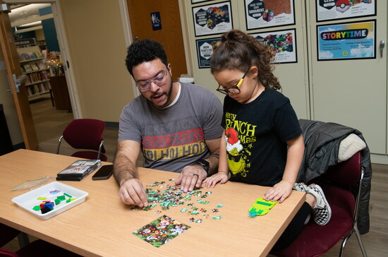 Families work on puzzles at the Manhattan-Elwood Public Library.