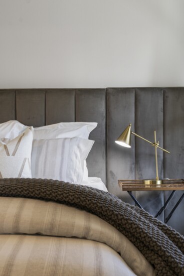 Little touches like lighting make this bedroom warm and inviting. Photo: Vast Media.