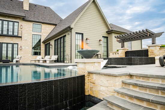 Fire bowls, a central fire pit and layered landscaping create an inviting outdoor space designed for gathering, relaxation and entertaining.