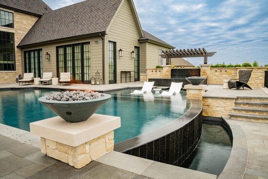 Inspired by the home's Romanesque architecture, the custom pool and surrounding courtyard blend timeless design with luxury outdoor living.