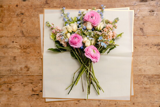Slide a piece or two of bouquet wrap, kraft paper, or even a recycled paper grocery bag underneath your bouquet