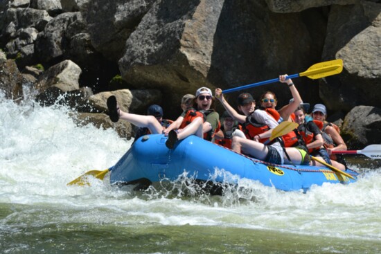 All smiles as the group heads over the rapids.